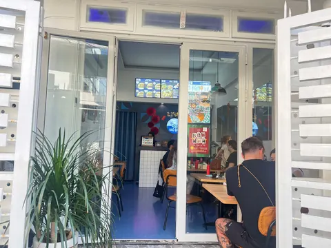 The open glass doors of Bao Bao seen from the street, with diners inside